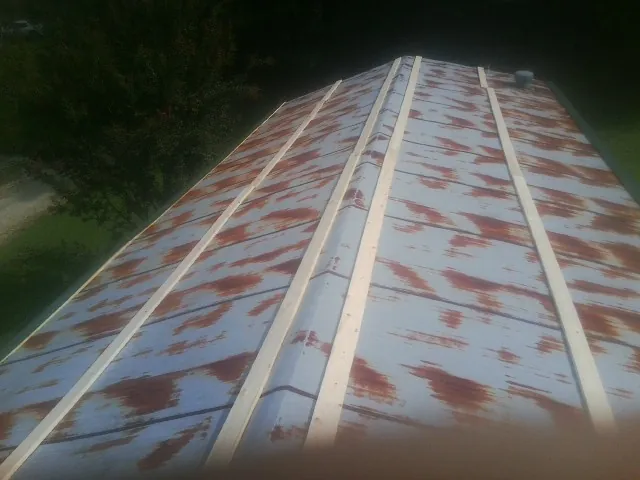 Rusted metal roof panels with new wood purlins before replacement — Storm Damage Roof Repair in Crucible by Roofing Brothers