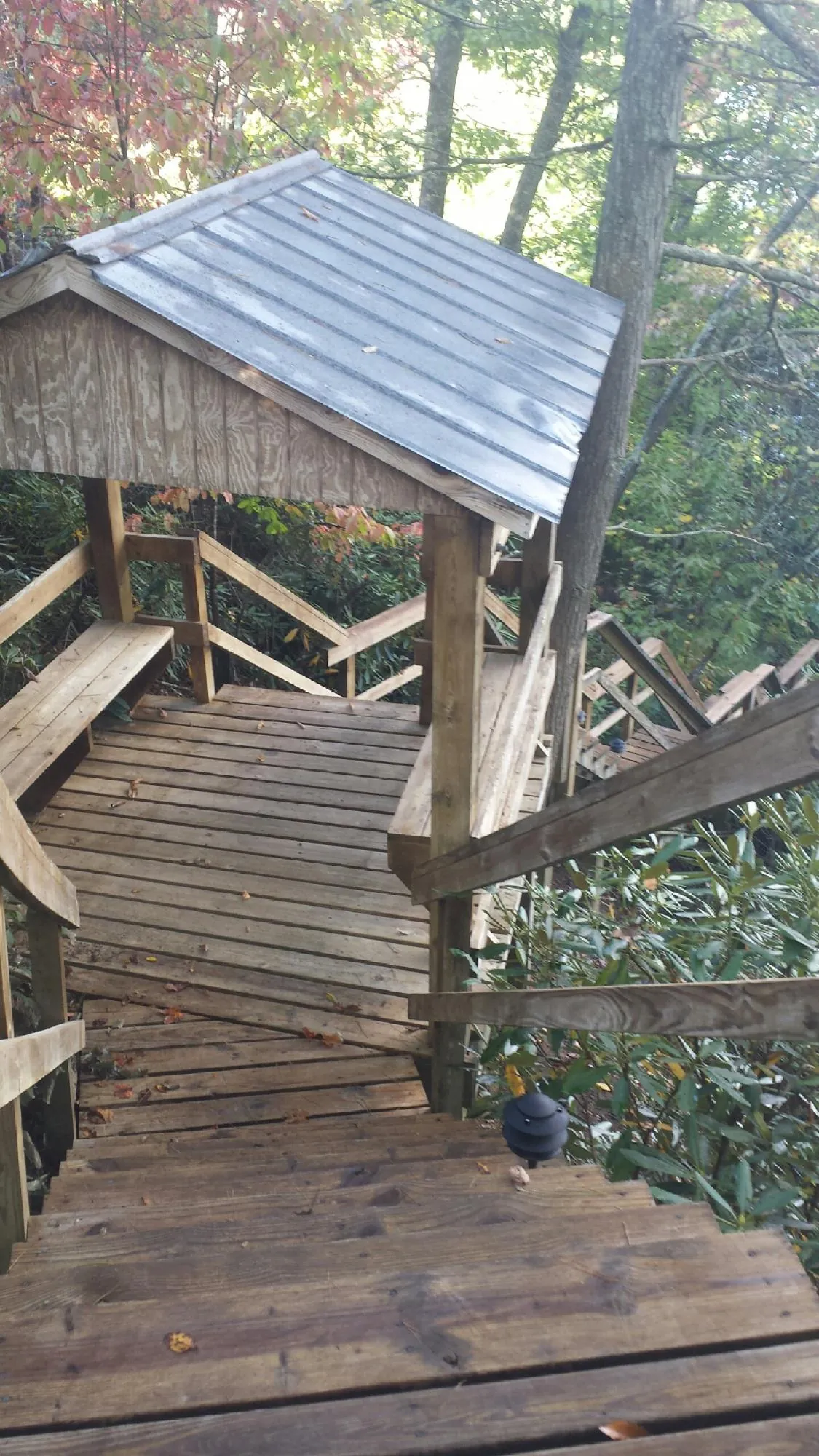 Metal roofed shelter over wooden steps on a wooded walkway — Skylight Repair & Installation work by our crew in Crucible