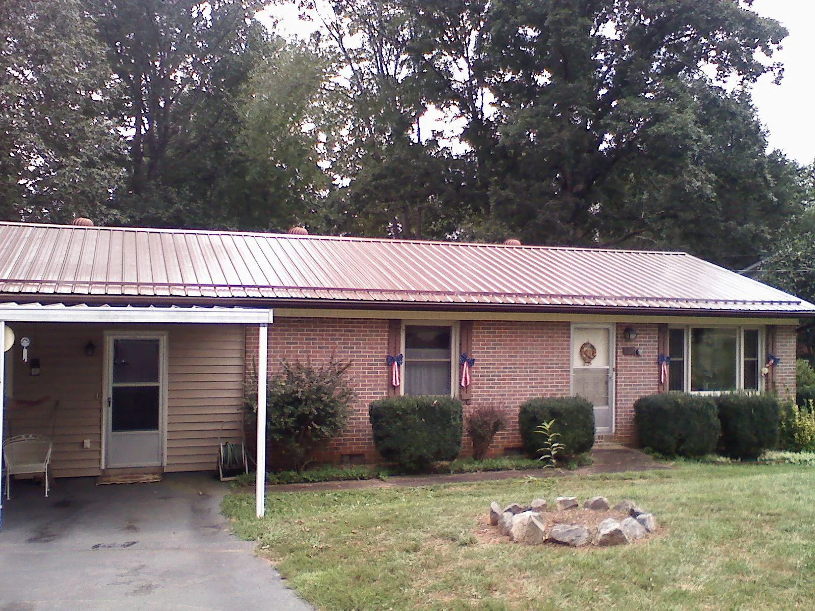 Bronze metal roof and carport on a brick ranch home — Roof Repair work by our crew in Crucible