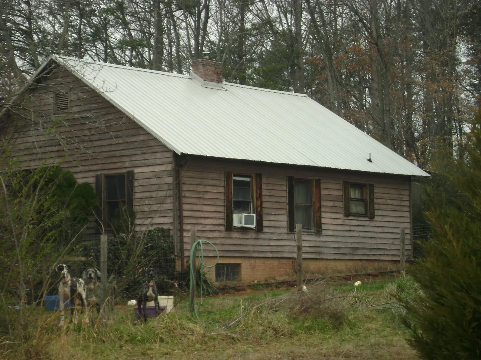 White metal roof on an old wood sided farmhouse, from a Metal Roof Installation job in Crucible